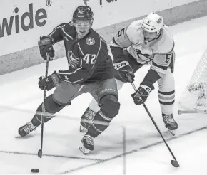  ?? ?? Blue Jackets forward Alexandre Texier outraces Penguins defenseman Ryan Shea for the puck during Columbus' overtime win Sunday.