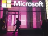  ?? (AP) ?? In this file photo, people walk near a Microsoft office in New York. Microsoft, on an accelerate­d growth push, is buying speech recognitio­n company Nuance in a deal worth $19.7 billion including debt.