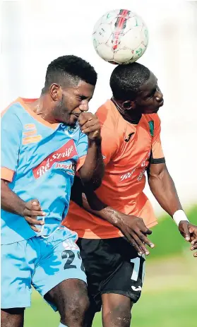  ?? RICARDO MAKYN ?? Sandals FC player Romaine Bennett (left) goes up for a header with Tivoli Gardens’ Authur Walters during their Red Stripe Premier League clash at the Edward Seaga Sports Complex. Tivoli Gardens won 1-0.