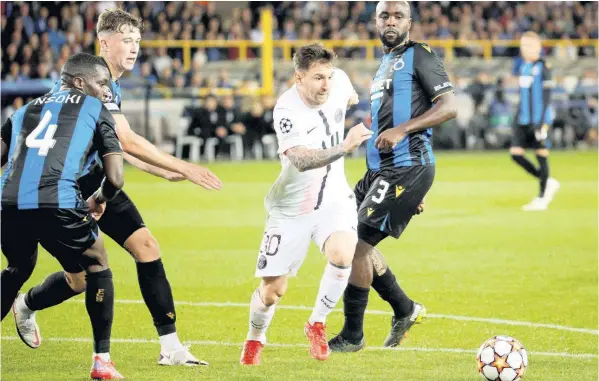  ?? AP ?? PSG’s Lionel Messi (centre) goes after the ball against Brugge’s Stanley Nsoki (left) and Eder Balanta (right) during the Champions League Group A soccer match at the Jan Breydel stadium in Bruges, Belgium, yesterday. The game ended 1-1.