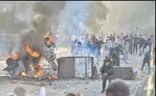  ?? PTI ?? People throw stones during clashes at Jafrabad in North-east Delhi on Monday. >>P5