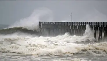  ?? (AFP) ?? Waves crash against a pier as the outer bands of Hurricane Michael arrive in Panama City Beach, Florida on Wednesday