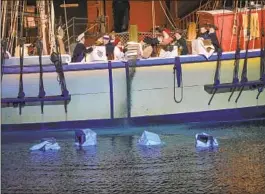  ?? Nicolaus Czarnecki MediaNews Group/Boston Herald via Getty Images ?? REENACTORS DUMP tea into the Boston Harbor on Dec. 16, 2017.
