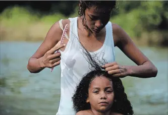  ?? REBECCA BLACKWELL THE ASSOCIATED PRESS ?? A Honduran migrant girl gets her hair combed after bathing in the river in Tapanatepe­c, Mexico, Sunday.