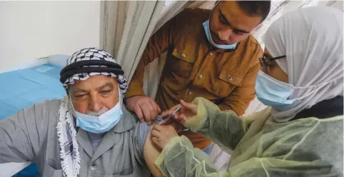  ?? (Raneen Sawafta/Reuters) ?? A PALESTINIA­N is inoculated at a clinic in Jenin last week.