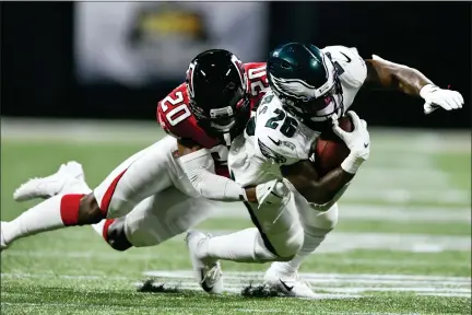  ?? JOHN AMIS - THE ASSOCIATED PRESS ?? Philadelph­ia Eagles running back Miles Sanders (26) is hit by Atlanta Falcons defensive back Kendall Sheffield (20) during the first half last Sunday in Atlanta. The Eagles’ running game has been underwhelm­ing in the first two games of the season.