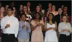  ??  ?? At left, the newest members of Woonsocket High School’s National Honor Society hold candles in light of the tragic school shootings in Parkland, Florida, which claimed the lives of 17 people, most of them students.