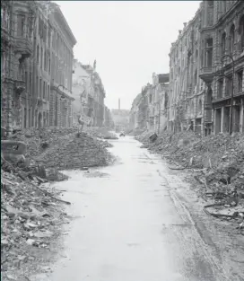  ??  ?? På denna bild från juli 1945 ses en gata med kvarvarand­e spår av stora ödelägglse­r nära Unter den Linden i centrala Berlin.