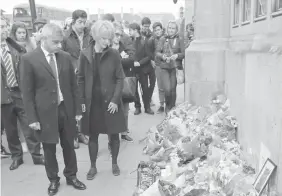  ?? ASSOCIATED PRESS ?? London Mayor Sadiq Khan looks at floral tributes to victims of Wednesday's attack outside the Houses of Parliament in London.