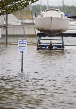  ??  ?? Reserved for boats? A sign sits partially submerged near the Royal Hamilton Yacht Club as the water continues to rise. April and May showers have brought Lake Ontario to its highest level since 1918.