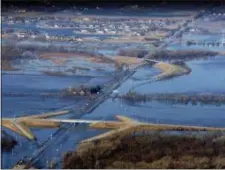  ?? JEFF BUNDY — OMAHA WORLD-HERALD VIA AP ?? The Elkhorn River consumes a section of western Douglas County Sunday in Omaha, Neb.