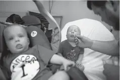  ?? Associated Press ?? ■ Kilian Daugherty, 1, gets his nose swabbed for the flu Friday by emergency department technician Jake Weatherfor­d as his sister Madison, left, waits to be examined at Upson Regional Medical Center in Thomaston, Ga.