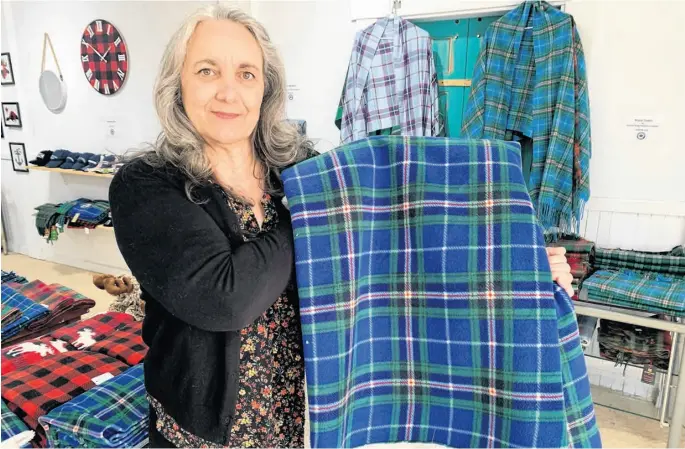  ?? DARRELL COLE ?? Sherrie Kearney looks over one of the products at Maritime Tartan that has moved from Halifax to a new location at 125 Victoria St. in Amherst.