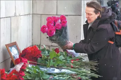  ?? ALEXANDER ZEMLIANICH­ENKO / ASSOCIATED PRESS ?? A woman pays her last respects in front of the portrait of the Russian UN ambassador Vitaly Churkin outside the Foreign Ministry headquarte­rs in Moscow on Tuesday.