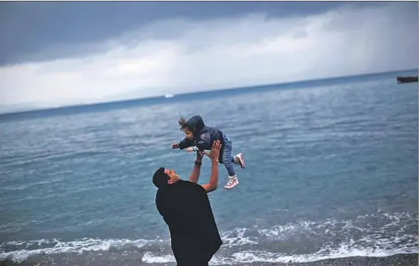  ?? DAN KITWOOD / GETTY ?? Mazen, refugiado sirio, jugando el pasado viernes con su hijo Bissan en una playa de Kos, Grecia; esperan papeles para ir a Europa