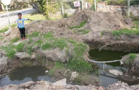  ?? Photos: Phillip Nyalungu ?? A child stands near a hole left unattended at the corner of Leicester and Bowles streets, in Westhill. 29 August 2017.