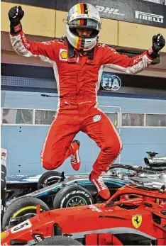  ?? Foto: afp ?? So kann man auch mal aus dem Auto aussteigen: Sebastian Vettel hüpft nach seinem Sieg von Bahrain voll Freude über die geparkten Boliden.