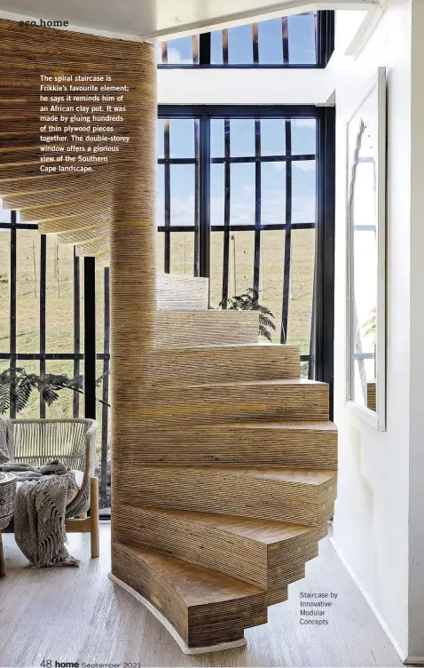  ??  ?? The spiral staircase is Frikkie’s favourite element; he says it reminds him of an African clay pot. It was made by gluing hundreds of thin plywood pieces together. The double-storey window offers a glorious view of the Southern
Cape landscape.
Staircase by Innovative Modular Concepts