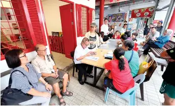  ?? — Photo by Kong Jun Liung ?? Yong (standing, left) oversees the meeting with the fire victims.