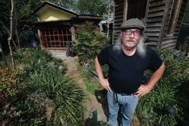  ?? Associated Press ?? n “Gestalt Gardener” horticultu­ralist Felder Rushing stands amid his wildflower and herb garden March 22 at his Jackson, Miss., home. Officials at Mississipp­i Public Broadcasti­ng say they do not know what would be cut if federal support for CPB...