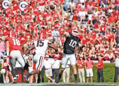  ?? DAVID BARNES/GEORGIA PHOTO ?? Tight end Isaac Nauta (18), outside linebacker D’Andre Walker (15) and then-quarterbac­k Jacob Eason (10) compete during Georgia’s G-Day spring game in 2016, which set an SEC attendance record with 93,000 fans.