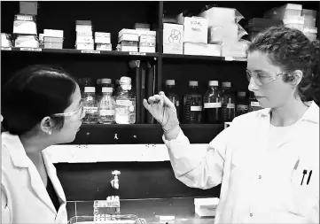  ??  ?? Associate professor Julie Liu, at left, and doctoral student Sydney Hollingshe­ad, prepare to test a new protein-based adhesive underwater. — Purdue University photo by Erin Easterling