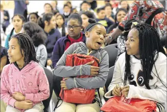  ?? HYOSUB SHIN / HSHIN@AJC.COM ?? Indigo Brown (center), 11, receives a laptop as part of Comcast’s Internet Essentials program during a Back to School event Wednesday at Morrow Middle School. The program provides discounted laptops and internet connection­s to low-income households, as...