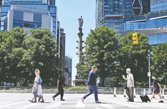  ?? ANGELA WEISS/AFP VIA GETTY IMAGES ?? People walk around Columbus Circle on Friday in New York City. Most consumers in a University of Michigan survey are pessimisti­c about the economy and worried about jobs.