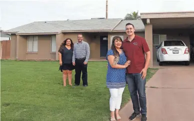  ?? PATRICK BREEN/THE REPUBLIC ?? Stephanie Silva and Billy Horner stand in the driveway of their new house with real estate agents Tia and Matthew Coates in Mesa on April 6.