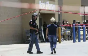  ?? MARK LAMBIE ?? FILE - In this Aug. 3, 2019, file photo, an employee crosses into the crime scene following a shooting at a Walmart in El Paso, Texas. Walmart has quietly hired off-duty officers at dozens of its stores across El Paso, where a gunman opened fire in August at one of the retail giant’s locations and killed 22people. The move comes as Walmart plans Thursday, Nov. 14, to reopen the store where the attack happened amid ongoing lawsuits over safety.