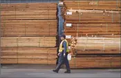  ?? Canadian Press photo ?? A worker walks past stacks of lumber at the Partap Forest Products mill in Maple Ridge, B.C., last week. A hefty American tariff on Canadian softwood could be devastatin­g for British Columbia's economy, but it may also be advantageo­us for political...