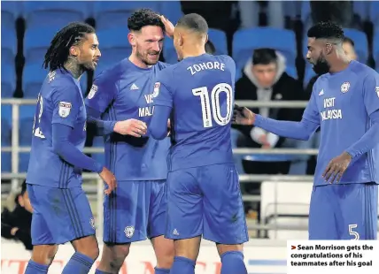  ??  ?? > Sean Morrison gets the congratula­tions of his teammates after his goal