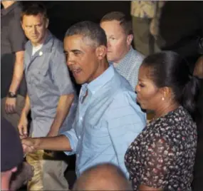  ?? THE ASSOCIATED PRESS ?? President Barack Obama and first lady Michelle Obama greet people before boarding Air Force One as they leave Joint Base Pearl Harbor-Hickam, adjacent to Honolulu, Hawaii, en route to Washington, on Sunday.