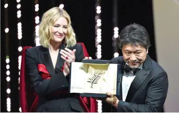  ??  ?? Kore-Eda poses on stage with actress and president of the jury Blanchett after he was awarded with the Palme d’Or for ‘Shoplifter­s (Manbiki Kazoku)’ on Saturday. — AFP photo