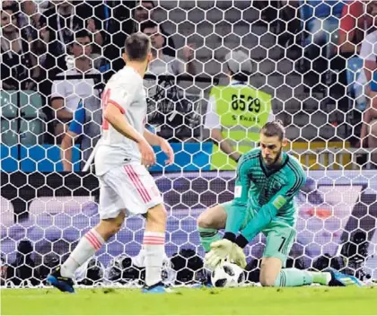  ?? AFP ?? David de Gea (derecha) colocó mal su cuerpo para atacar un remate de Cristiano Ronaldo y la pelota terminó en el fondo de las redes, en el encuentro que culminó 3 a 3 entre españoles y portuguese­s.