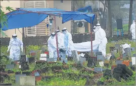  ??  ?? Health workers bury the body of a 12-year-old boy who died of Nipah virus at the Kannampara­mbu cemetery in Kozhikode on Sunday.