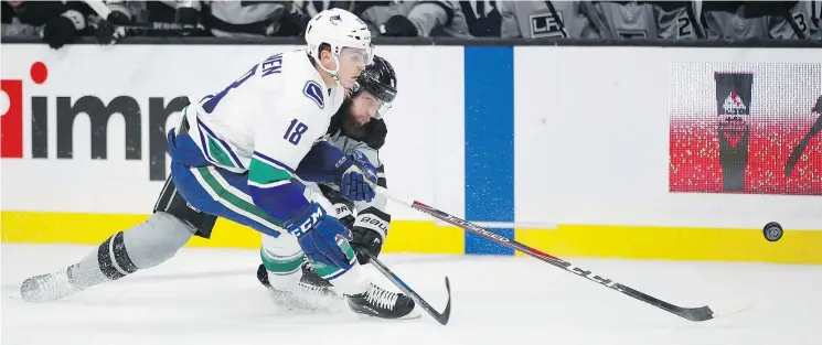  ?? — AP PHOTO ?? Vancouver’s Jake Virtanen and the Kings’ Jake Muzzin race for the puck during Saturday’s game in L.A. The Canucks won on a third-period goal by Elias Pettersson.