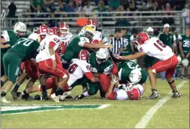  ?? LARRY GREESON / For the Calhoun Times ?? Several members of the Sonoravill­e defense rally to bring down Adairsvill­e running back Christian Steele (22) during the first half on Friday.