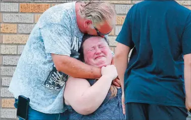  ?? MICHAEL CIAGLO/HOUSTON CHRONICLE VIA AP ?? A man hugs a woman outside the Alamo Gym, where parents wait to reunite with their children following a shooting at Santa Fe High School in Santa Fe, Texas.