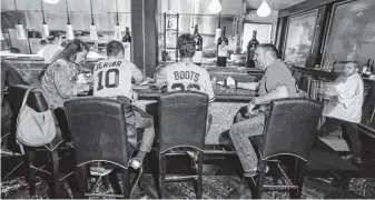  ?? Steve Gonzales / Staff photograph­er ?? New York Yankees and Astros fans enjoy a meal together at Vic & Anthony’s before the start of an ALDS game at Minute Maid Park.