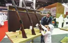  ?? Abdul Rahman/Gulf News ?? Six-year-old Shaikh Zayed Bin Sultan Rashid Al Nuaimi takes a look at at the latest hunting rifles at the Blaser pavilion.
