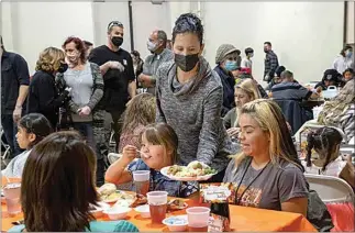  ?? ROD THORNBURG / FOR THE CALIFORNIA­N ?? A volunteer serves Marlene Evans and her daughter, Paisley, during the Thanksgivi­ng meal at The Mission at Kern County. See more photos on Page A3 and online at Bakersfiel­d.com.