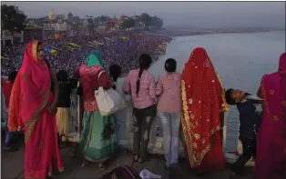  ?? MANISH SWARUP — THE ASSOCIATED PRESS ?? Families watch from a bridge as thousands of people enter the holy River Saryu in Ayodhya, India, last month. The United Nations says India will be the world’s most populous country by the end of this month, eclipsing an aging China.