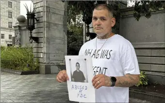  ?? HOLLY RAMER — THE ASSOCIATED PRESS ?? Michael Gilpatrick holds a copy of his intake photo from New Hampshire’s youth detention center as he and other former residents of the Youth Developmen­t Center, now called the Sununu Youth Services Center, hold a rally outside the Statehouse in Concord, Friday.