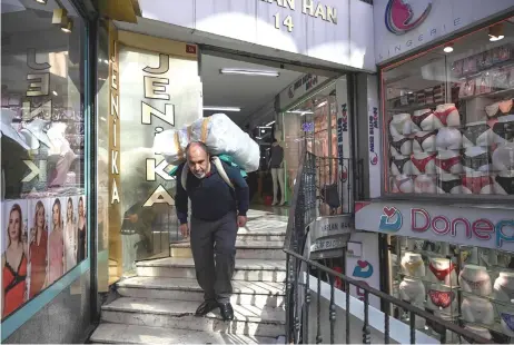  ?? — AFP photo ?? Toktas carries belongings on the stairs near Grand Bazaar in Istanbul.
