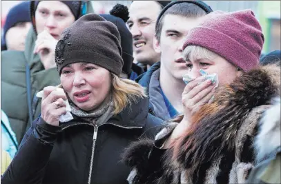  ?? Sergei Gavrilenko ?? The Associated Press People weep Monday for the victims of a fire at a shopping center in Kemerovo, Russia. The popular mall in the Siberian city was filled with families when the fire broke out, and 64 people were killed.