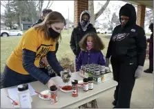  ??  ?? Amanda Hornberger, program director at the Jewish Federation of Reading/Berks, shows volunteers how to assemble the ingredient­s for a bean soup mix during a Martin Luther King Jr. Day program at Immanuel United Church of Christ in Shillingto­n Monday morning. Watching, from left, are Simon Bolich, 12, hi s sister Vivienne, 7, and their mother Rayna, of Exeter.