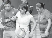  ??  ?? Barbara Barca, a survivor of the stampede at a crowded nightclub, is helped by relatives as they leave police headquarte­rs in Caracas, Venezuela, on Saturday.