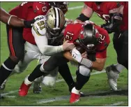  ?? (AP/Mark LoMoglio) ?? New Orleans Saints defensive end Trey Hendrickso­n (91) sacks Tampa Bay Buccaneers quarterbac­k Tom Brady during the second half Sunday in Tampa, Fla. The Saints dominated the Bucs to win 38-3.