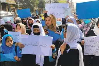  ?? MOHAMMED SHOAIB AMIN AP ?? Afghan women chant and hold signs of protest during a demonstrat­ion in Kabul, Afghanista­n, on Saturday. Afghanista­n's Taliban rulers refused to allow dozens of women to board several flights.